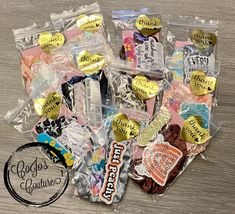 a bunch of candies are sitting in a bag on the table next to some stickers