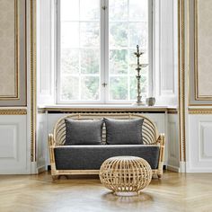 a wicker couch sitting in front of a window