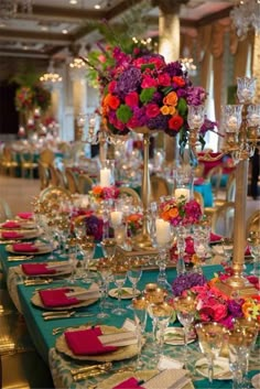 the table is set with colorful flowers and candles