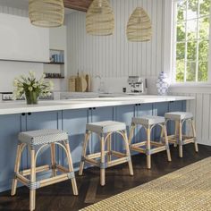 four stools are lined up in the kitchen