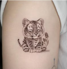 a small tiger tattoo on the thigh