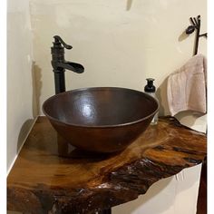 a bowl sink sitting on top of a wooden counter next to a faucet