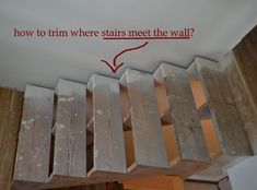 the stairs are being built and painted with red marker on it's wall above them is a sign that says, how to turn where stairs meet the wall?