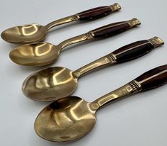 five antique spoons are lined up in a row