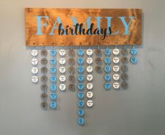 a wooden sign hanging from the side of a wall with blue and white buttons attached to it