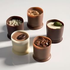 four different types of chocolate desserts on a white surface