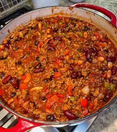 a pot filled with chili and beans on top of a stove