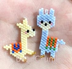 two pieces of beaded animal are sitting on someone's hand, one is holding the other