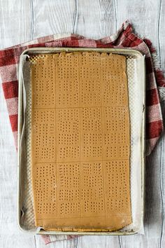 a baking pan filled with peanut butter and graham crackers on top of a red and white checkered towel