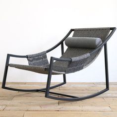 a rocking chair with grey cushions on wooden floor