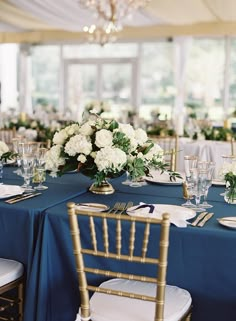 the tables are set with blue linens and white flowers