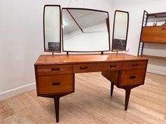 a wooden desk with two mirrors on it