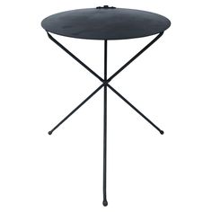 a round table with black metal legs and an iron frame on the top, against a white background