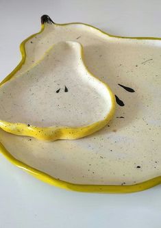 a yellow and white dish with black speckles on it