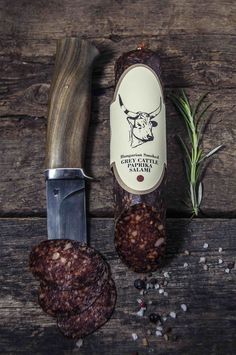 a knife and some food on a wooden table next to an animal's head