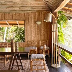 an outdoor dining area with wicker walls and wooden flooring, rattan chairs and table