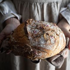 a person holding a loaf of bread in their hands