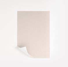 a piece of white paper with a corner cut out on the side, in front of a plain wall