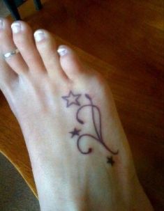 a woman's foot with a star tattoo on it