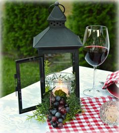 a table topped with a glass of wine and a lantern