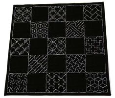 a black and white patchwork quilt on a white background with stitching in the middle