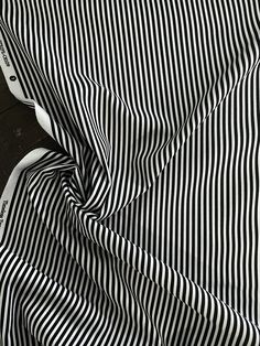 a black and white striped shirt laying on top of a wooden floor