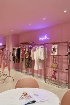 the inside of a clothing store with pink walls