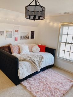 a bedroom with a bed, rugs and pictures hanging on the wall above it