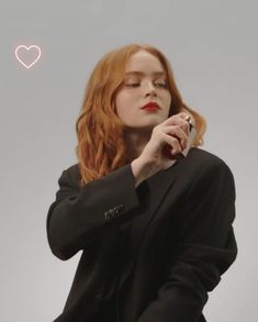 a woman with red hair holding a cell phone