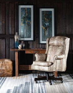 an office chair sitting in front of a desk with two paintings on the wall behind it