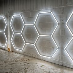 a white brick wall with several hexagonal lights on it's sides and the bottom part of the wall lit up