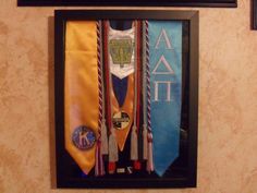 a group of ties hanging on a wall next to framed pictures and plaques above them