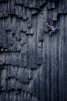 a man climbing up the side of a cliff