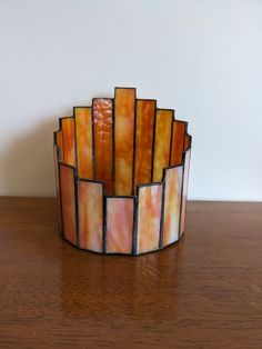 a stained glass vase sitting on top of a wooden table