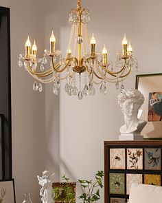 a gold chandelier hanging from the ceiling in a room with pictures on the wall