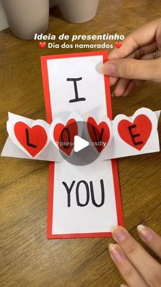 someone is making a card with the words i love you and two hearts on it