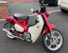 a red and white motorcycle parked in a parking lot