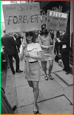 two women walking down the street holding up signs that read, mind smarts forever