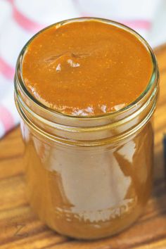 a jar filled with brown liquid sitting on top of a wooden table