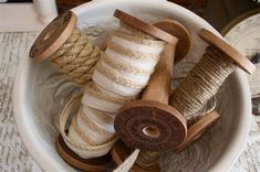 several spools of twine in a bowl on a table with other items