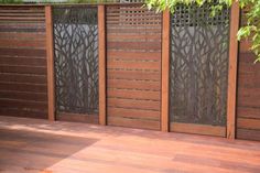 a wooden deck with an iron fence and privacy screen on the top part of it