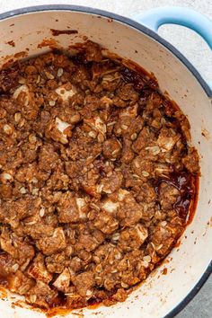 a pot filled with meat and sauce on top of a table