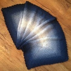 four pieces of blue cloth on a wooden floor