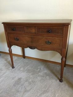 an old wooden table with two drawers on one side and a drawer on the other