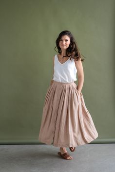 Feminine meets practical - this wonderfully woven sweet button-down skirt is flattering, has a softly gathered waist, deep pockets, and pairs well with any kind of fashion sense. Functional buttons descending down the front, create the perfect summer day look. Carefully gathered folds both in front and back create a beautiful A-line shape. It is made of natural linen, which makes you feel comfortable, free in movements and also very special. It fastens with front buttons and sits best when high Daywear Button-up Bottoms With Pockets, Cotton Button-up Lined Skirt, Relaxed Button-up Lined Skirt, Cotton Flared Skirt With Buttons, Daywear Flared Skirt With Pockets, Casual Long Skirt With Button Closure, Casual Full Skirt With Button Closure, Casual Full Skirt Bottoms With Button Closure, Long Skirt With Pockets For Daywear