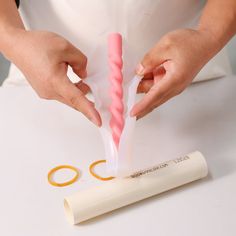 a woman is holding two toothbrushes in one hand and an orange pair of scissors in the other