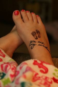 a woman's foot with a tattoo saying you are my sunshine on her left side