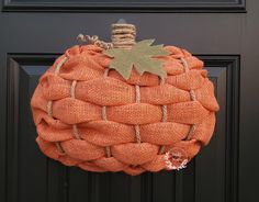 an orange burlocked pumpkin hanging on the front door