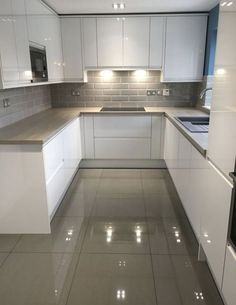 an empty kitchen with white cabinets and silver counter tops is seen in this image from the front view