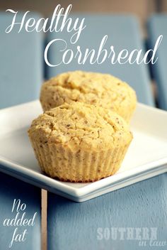 two muffins sitting on top of a white plate next to a blue table